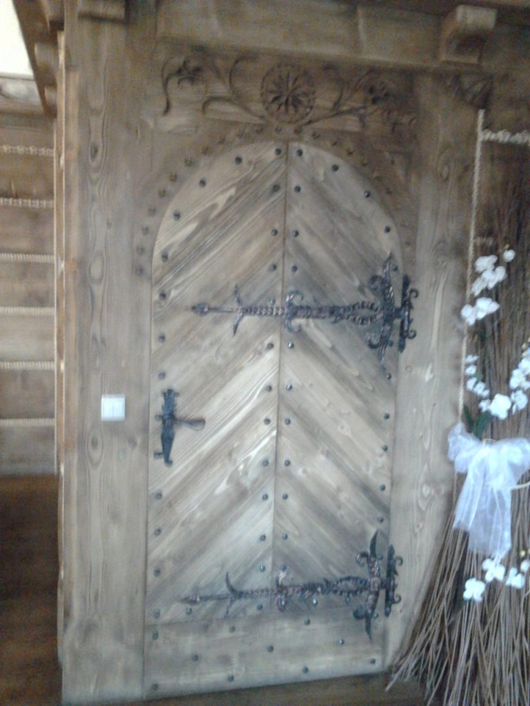 drzwi wejsciowe drewnianw z ozdobnymi ćwiekami
